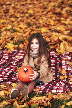 Six Old Year Girl With Pumpkin Sitting In Autumn Park