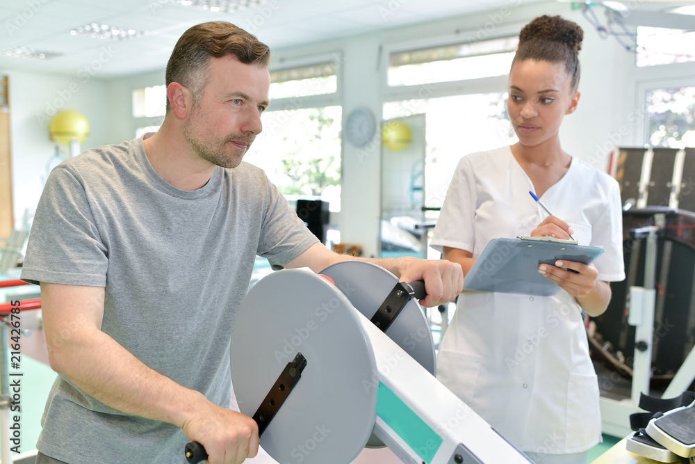 male patient with female physio therapist working out arms
