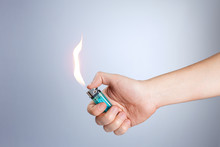 Hand Burning A Lighter On White Background