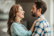 © Yakobchuk Olena - Side view cheerful wife embracing outgoing unshaven husband. They talking together
