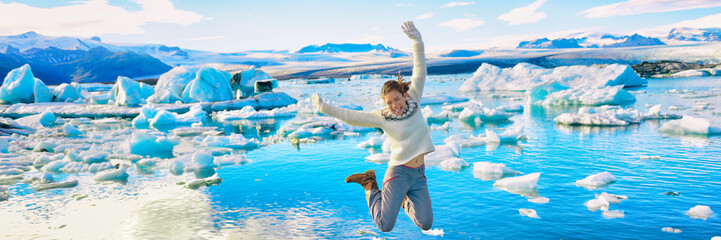 Wall Mural - iceland jökulsárlón glacier lagoon tourist woman jumping of happiness - icelandic touristic destinat