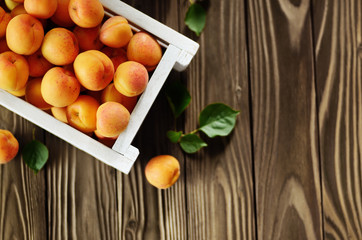 Poster - White wooden crate with apricots on table. Top View.