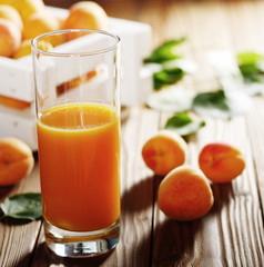 Poster - Apricot smoothie in glass on wooden table with crate at background