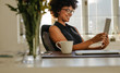 © Jacob Lund - Happy woman using digital tablet in office