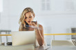 © Jacob Lund - Woman at cafe with laptop making phone call
