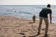 man with dog enjoying free time on the beach