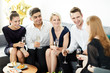 © pressmaster - Group of cheerful friends in smart clothes sitting on sofa, having champagne and talking at party