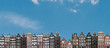 Panorama or panoramic view. Traditional houses in Amsterdam in the Netherlands in a row against the blue sky.