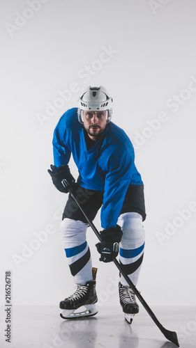 Fototapeta na szkło Portrait of Caucasian male ice hockey player in uniform posing against white background