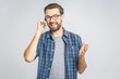 © denis_vermenko - Oh, great news! Smiling young casual man talking on the phone on the grey background. Isolated.