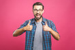 © denis_vermenko - Portrait of young man in glasses showing thumbs up isolated over pink background