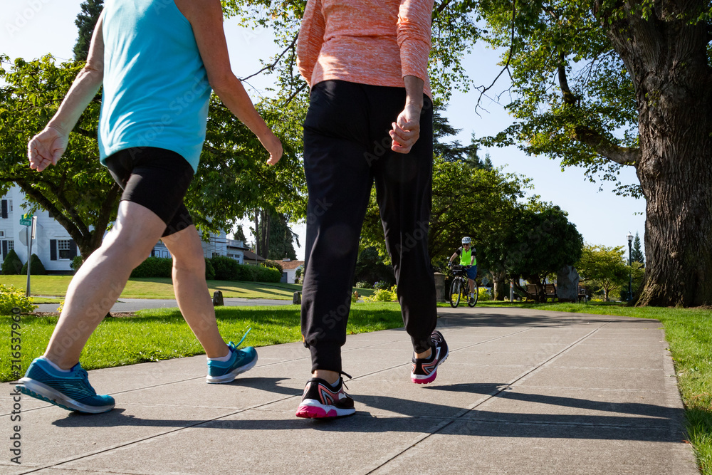 Two Women Walking Down Path in Park Stock Photo | Adobe Stock