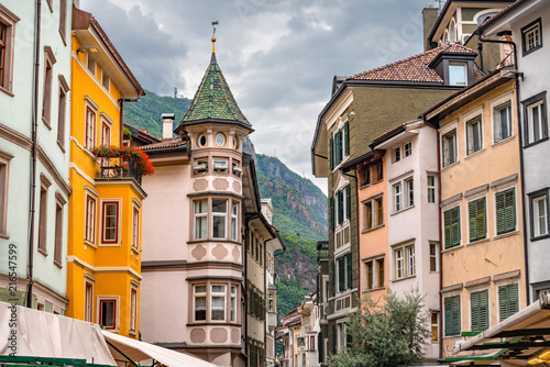 Fotografie, Obraz Colorful historic buildings in the city center of Bolzano with high mountains in