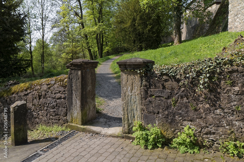 Fotografía An old stone passage in the park with a path in the background