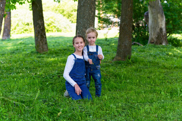 pretty baby boy and toddler girl playing in summer park