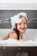 © Lisa Tichané - Young girl with missing teeth smiling in soapy bubble bath