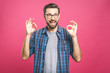 © denis_vermenko - A handsome man in checkered shirt isolated on pink background showing ok sign