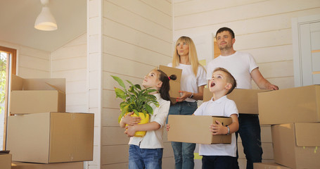 Happy family with two children at new home. Mother father and child in new house