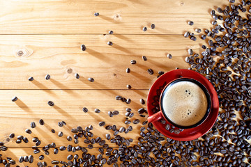 Cup of Coffee on a wooden table a scattering of coffee beans