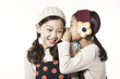 © dohee - two girls whispering each other isolated white.