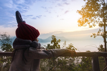 Asian girl l wears a red hat watching the sAsian child girl wearing red hat watching sunrise landscapeunrise landscape.