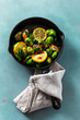 Top view fried brussels sprouts served in cast iron frying pan on blue stone background Healthy Vegetarian Food
