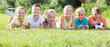 © JackF - Group of friendly kids lying on green grass in park