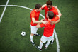 © pressmaster - Three young footballers embracing and making circle while standing on green field