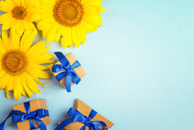 Blue Background With A Yellow Sunflowers And Gift Boxes With Blue Ribbons