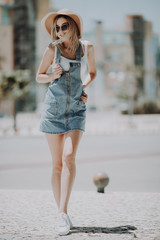 Poster - Beautiful full height young woman wearing dress and walking on the street