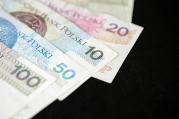 Several banknotes of Polish zloty on a dark background close up