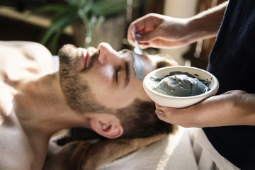 Man getting a mud mask at a spa