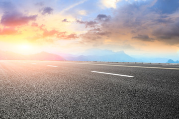 Asphalt highway and mountain landscape at sunset