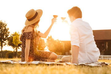 Loving couple sitting by dating drinking wine.