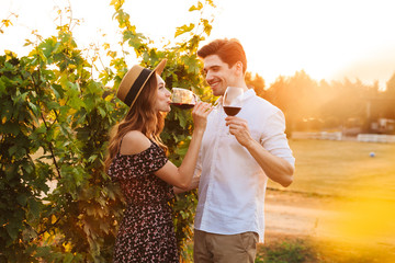 Poster - Happy loving couple outdoors drinking wine.