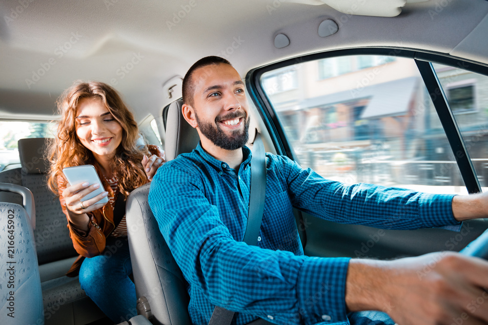Uber driver sitting in a car with female passenger Stock Photo | Adobe Stock