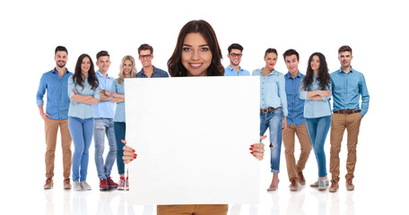 Wall Mural - smiling businesswoman holding empty board in front of her group