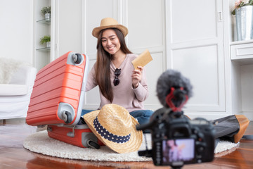 Wall Mural - Asian young female blogger recording vlog video with vacation preparing to travel trip at home.online influcencer on social media concept.