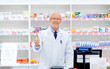 medicine, healthcare and people concept - senior apothecary at pharmacy cash register showing thumbs up