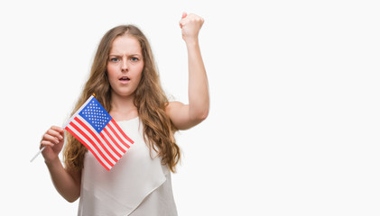 Sticker - Young blonde woman holding flag of USA annoyed and frustrated shouting with anger, crazy and yelling with raised hand, anger concept