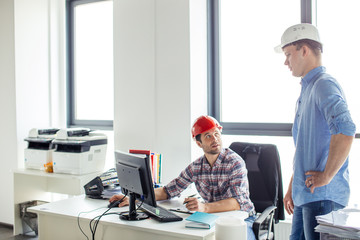 Wall Mural - two talented successful engineers discussing work together in office with panorama window. close up photo. job concept