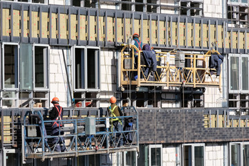 New building construction site with scaffolding and workers