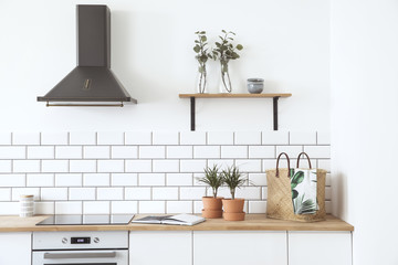 Wall Mural - Stylish scandinavian open space with kitchen accessories, plants. Design room with white walls.