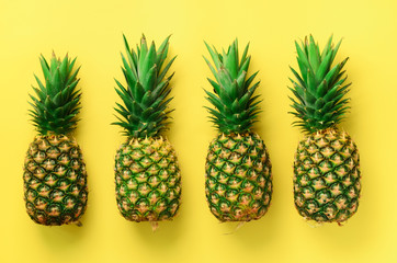Wall Mural - fresh pineapples on yellow background. top view. pop art design, creative concept. copy space. brigh