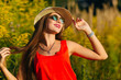 © Ivan - Stylish young girl in her hat raises her arms to her head agains