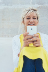 Wall Mural - Middle-aged smiling woman using mobile phone