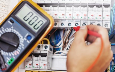 Hand of an electrician with multimeter probe