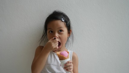 Wall Mural - Cute little girl eating ice-cream and big smiling 