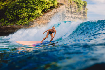 Wall Mural - Surfer woman ride on wave surfing. Surfer and ocean wave in Bali