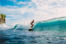 Surfer Woman On Surfboard During Surfing. Surfer And Ocean Wave